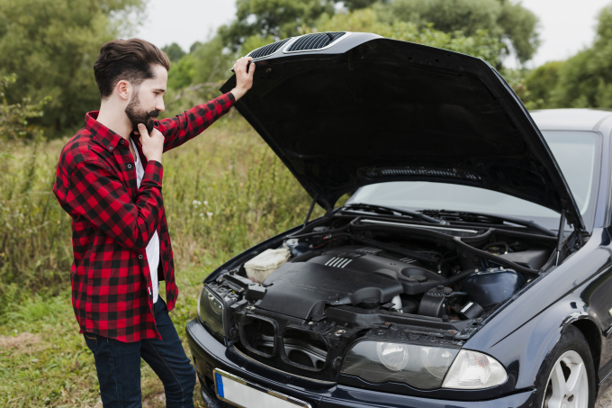 man-leaning-open-car-hood